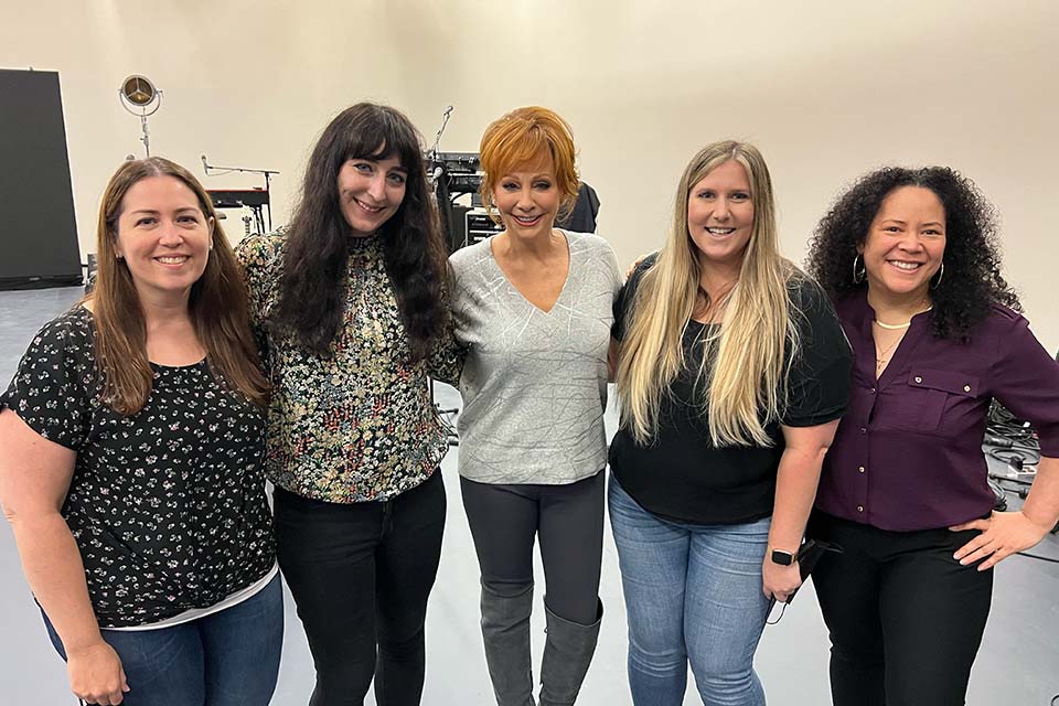 Leah (Ducey) Dougherty poses for a photo with Reba McEntire and three others.
