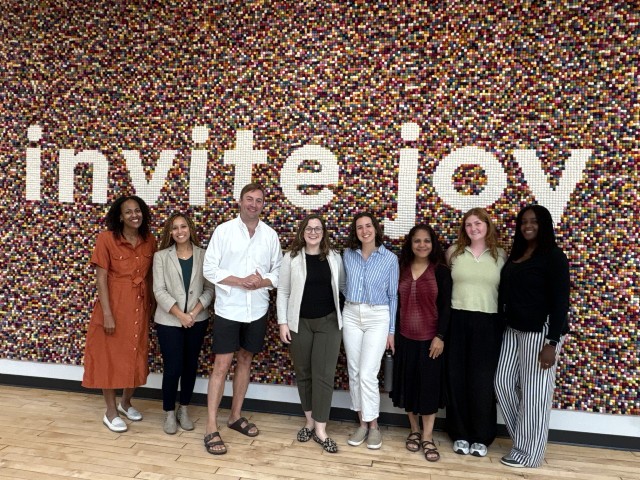 Photo of PRiME Center Team in front of a mural that says invite joy