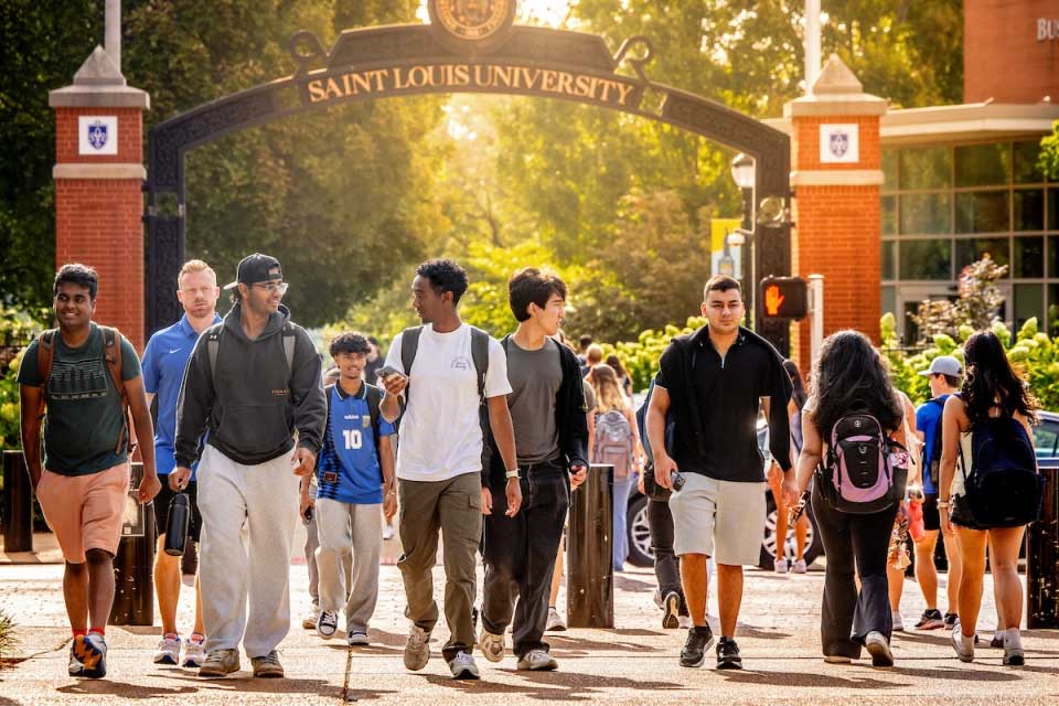 Students cross Grand in front of SLU's pedestrian gate.
